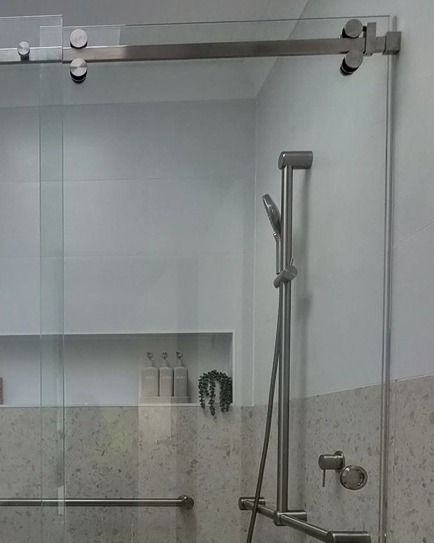 Close view of frameless sliding door hardware in Northmead