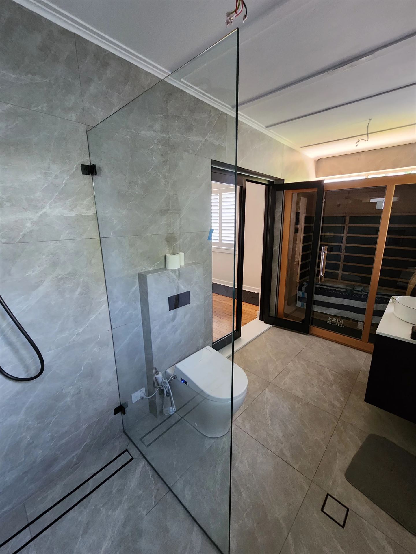 frameless shower screen with black hardware installed in Denistone East by Showerland