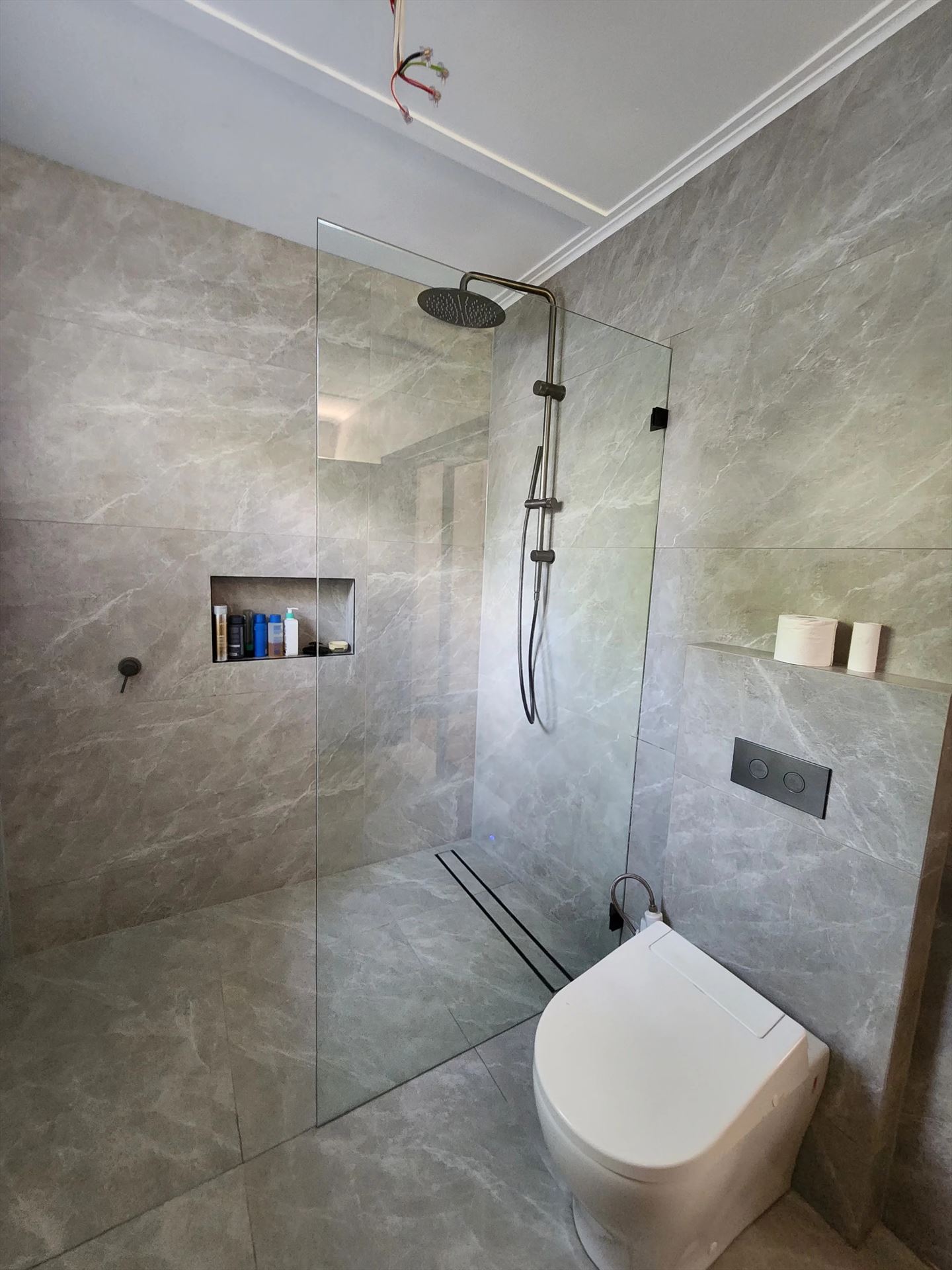 frameless shower screen with black hardware installed in Denistone East by Showerland