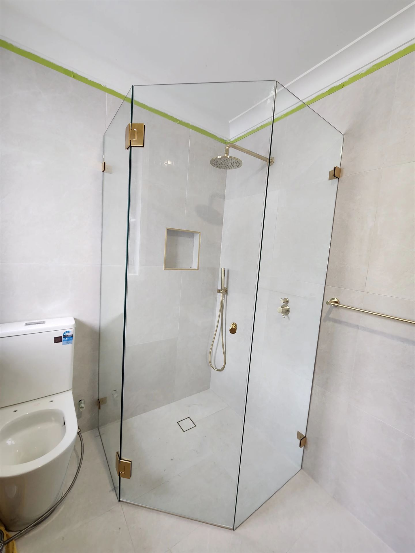 frameless shower screen with gold hardware installed in Kellyville Ridge by Showerland