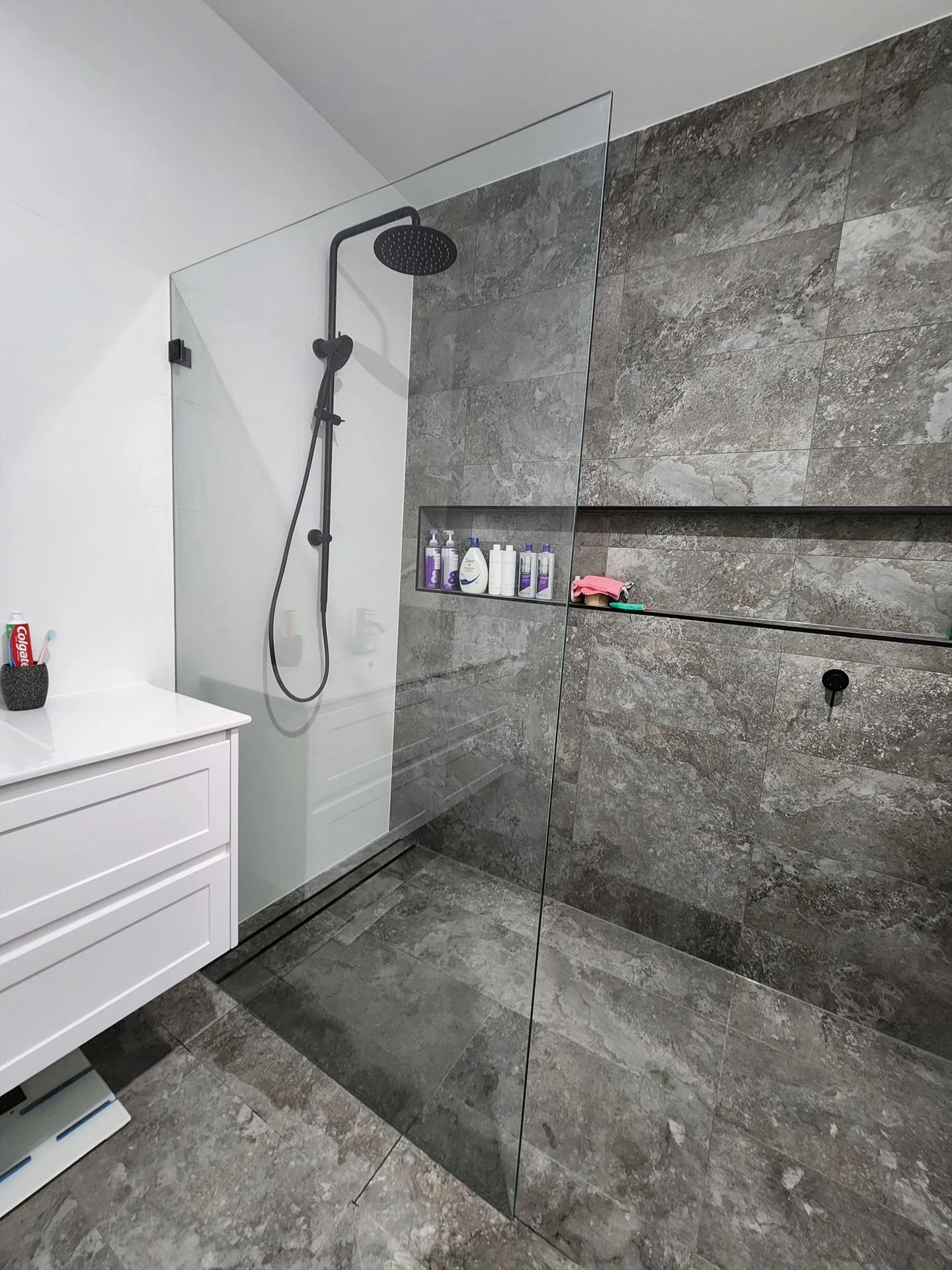 frameless shower screen with black hardware installed in Oakville by Showerland