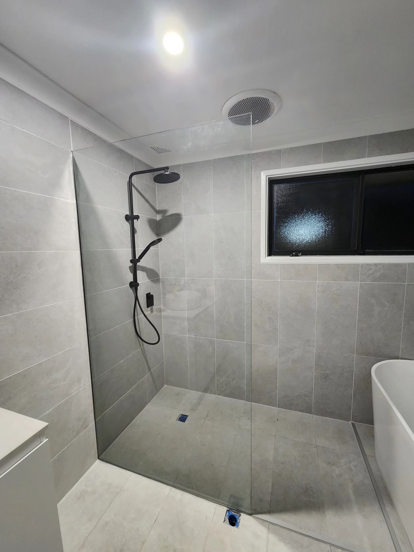 frameless shower screen with black hardware installed in Quakers Hill by Showerland