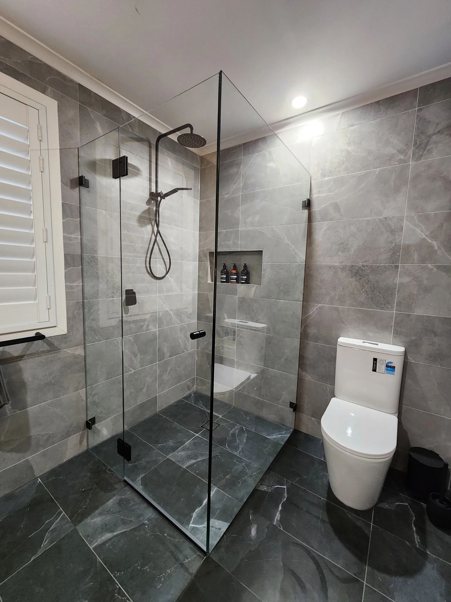 frameless shower screen with black hardware installed in Newington by Showerland