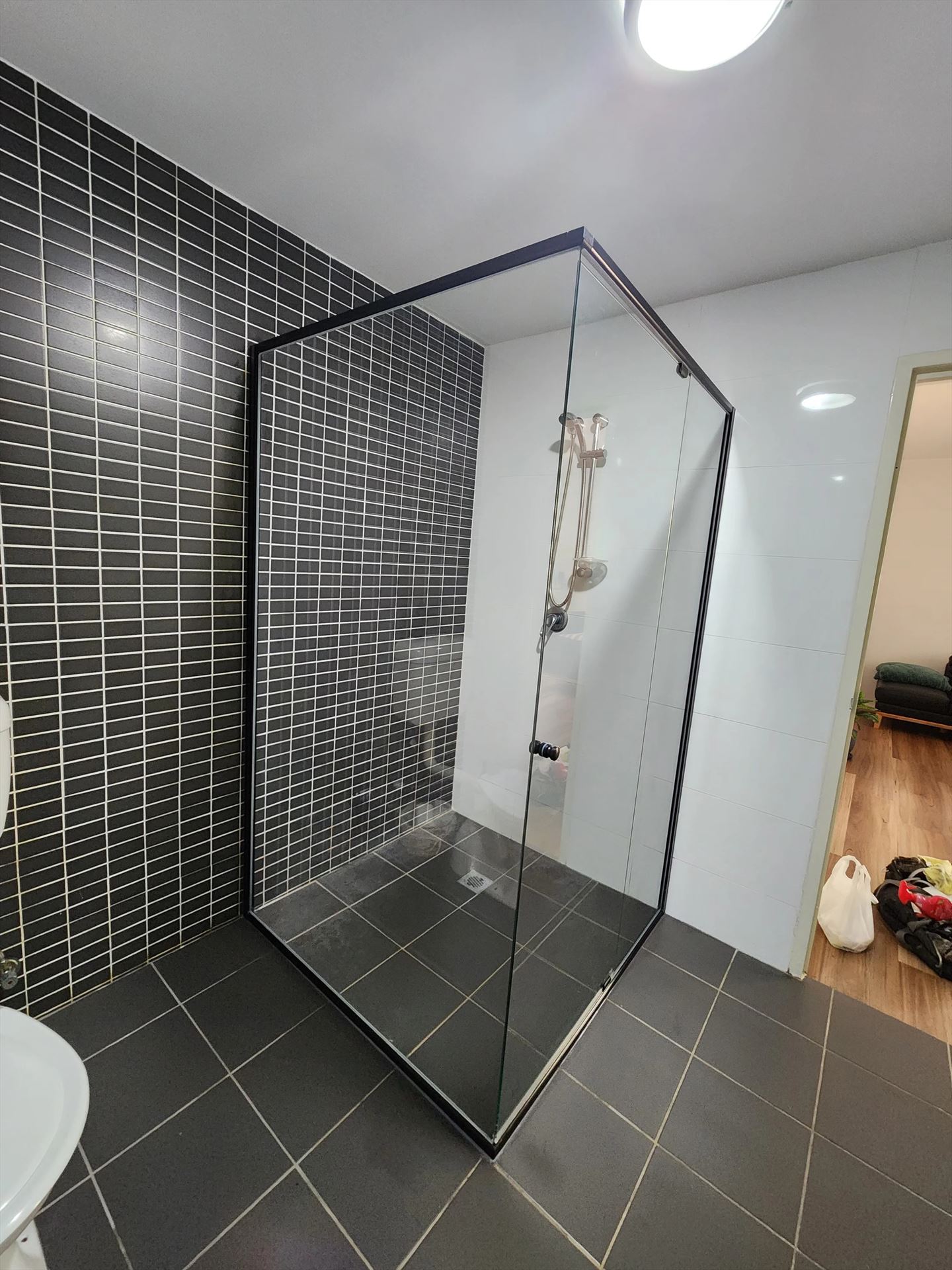 semi shower screen with black hardware installed in Westmead by Showerland