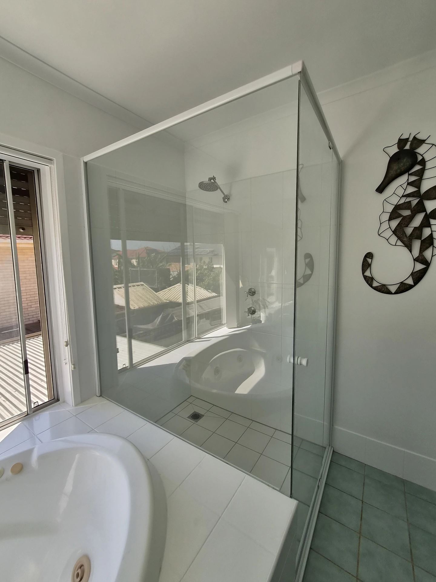 frameless shower screen with white hardware installed in Woodcroft by Showerland
