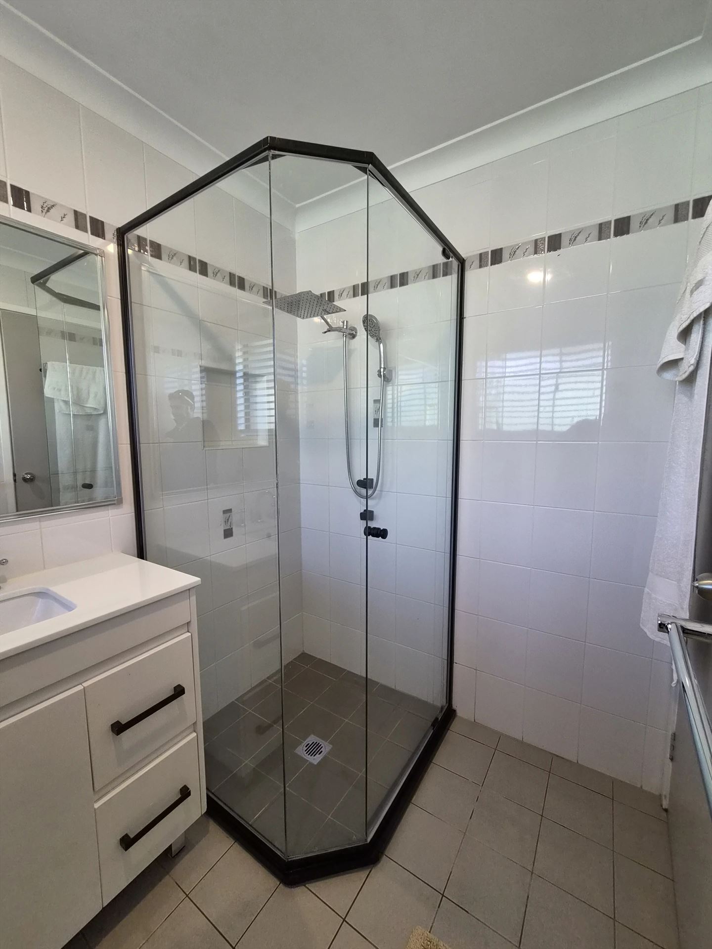 semi shower screen with black hardware installed in Colyton by Showerland