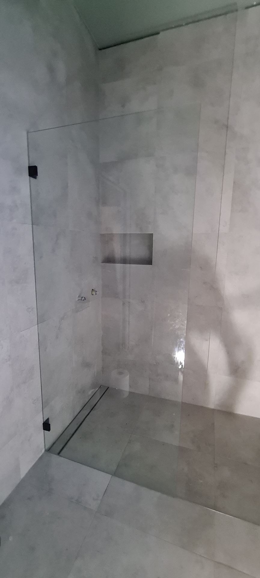 frameless shower screen with black hardware installed in Concord West by Showerland
