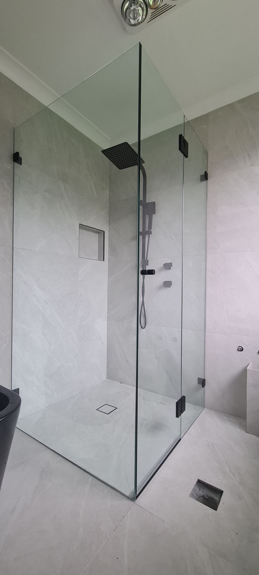 frameless shower screen with black hardware installed in Acacia Gardens by Showerland