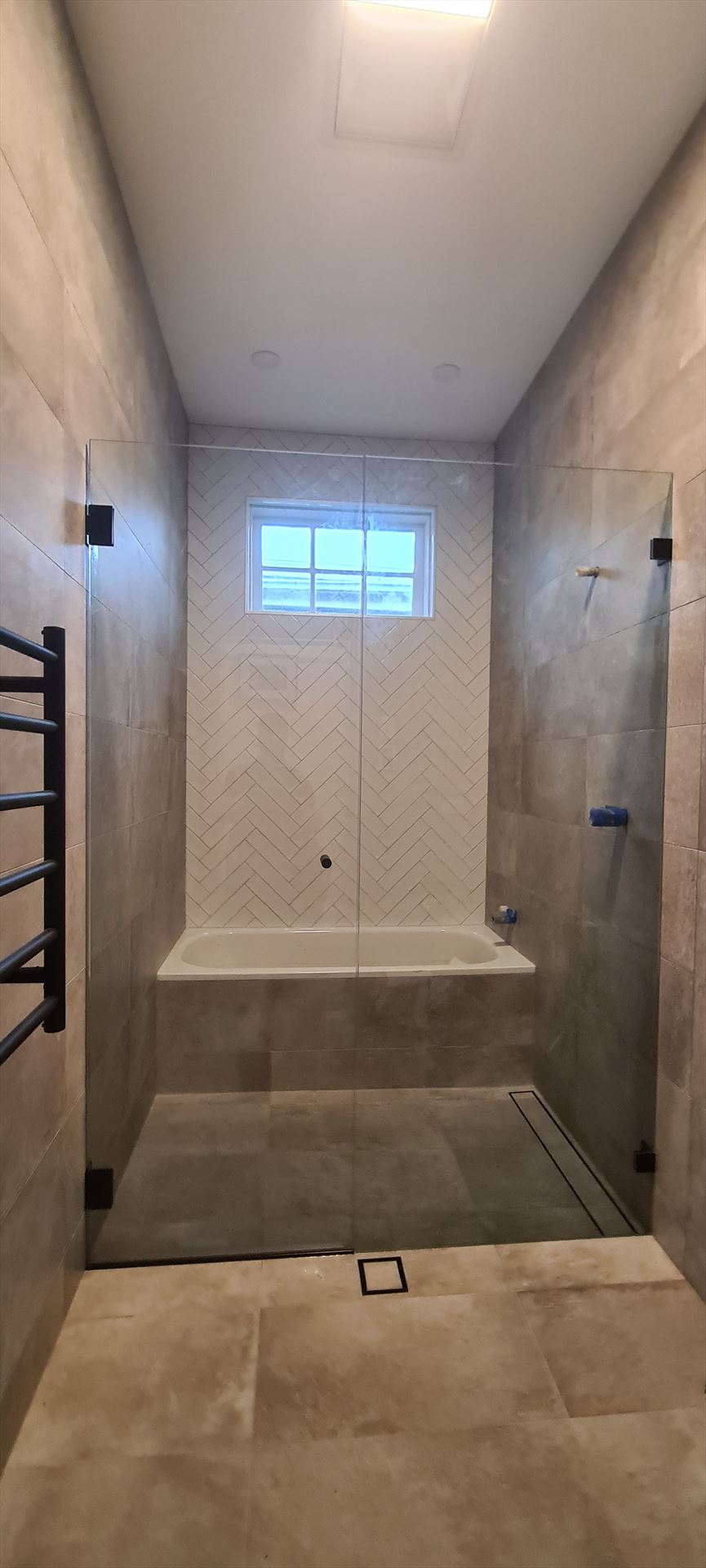 frameless shower screen with black hardware installed in Maroubra by Showerland