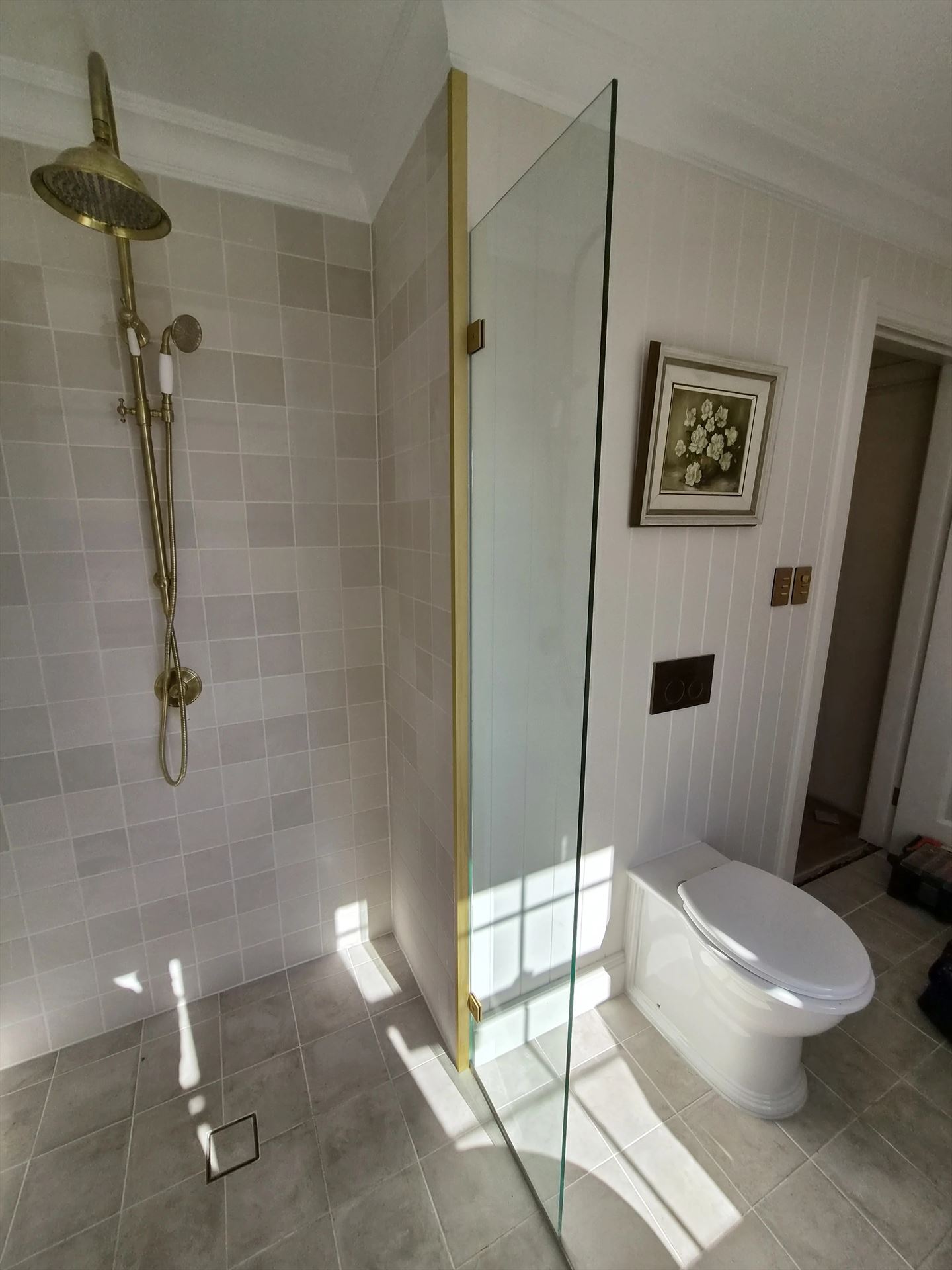 frameless shower screen with gold hardware installed in Blacktown by Showerland