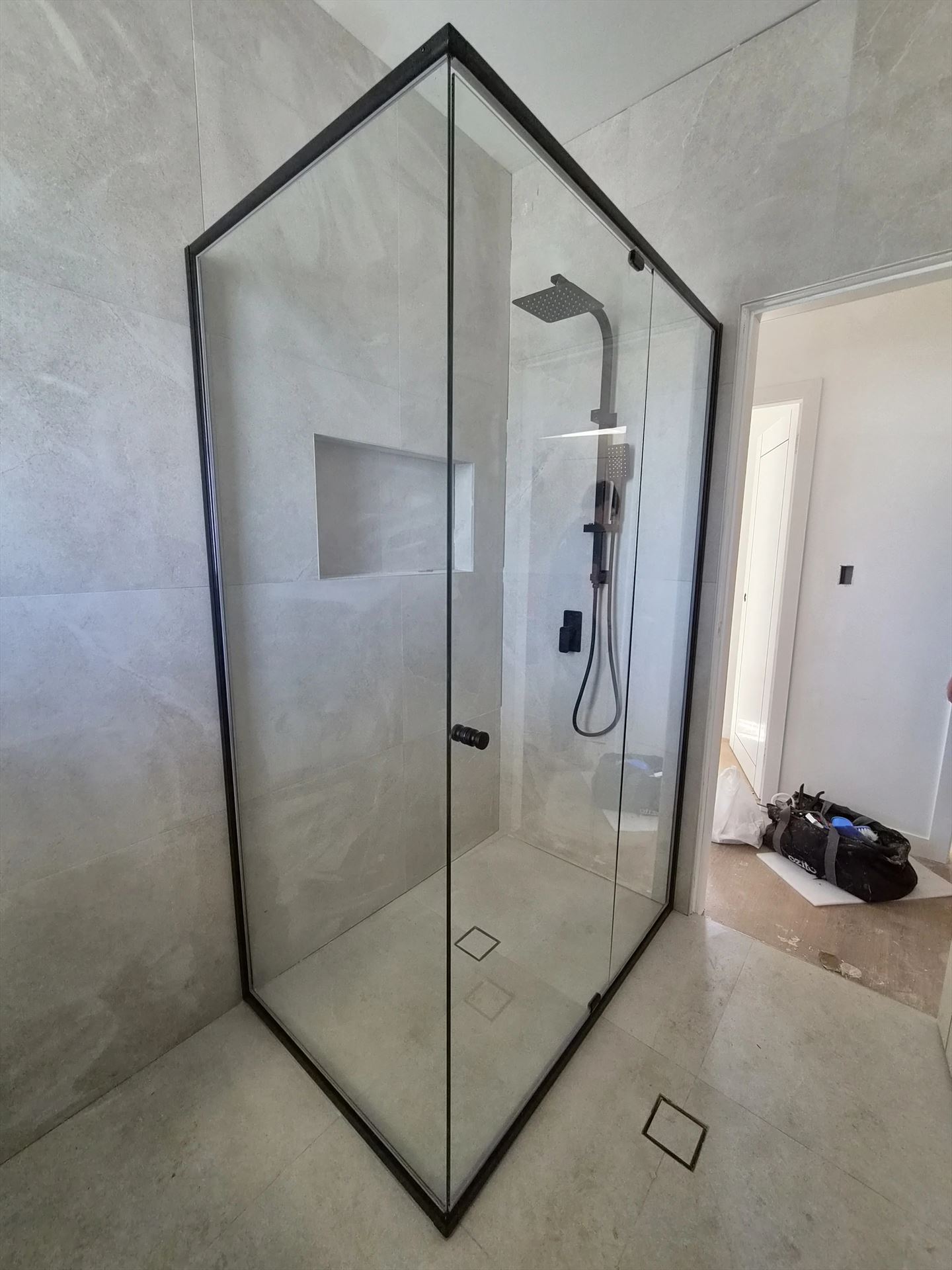 frameless shower screen with black hardware installed in Kingswood by Showerland
