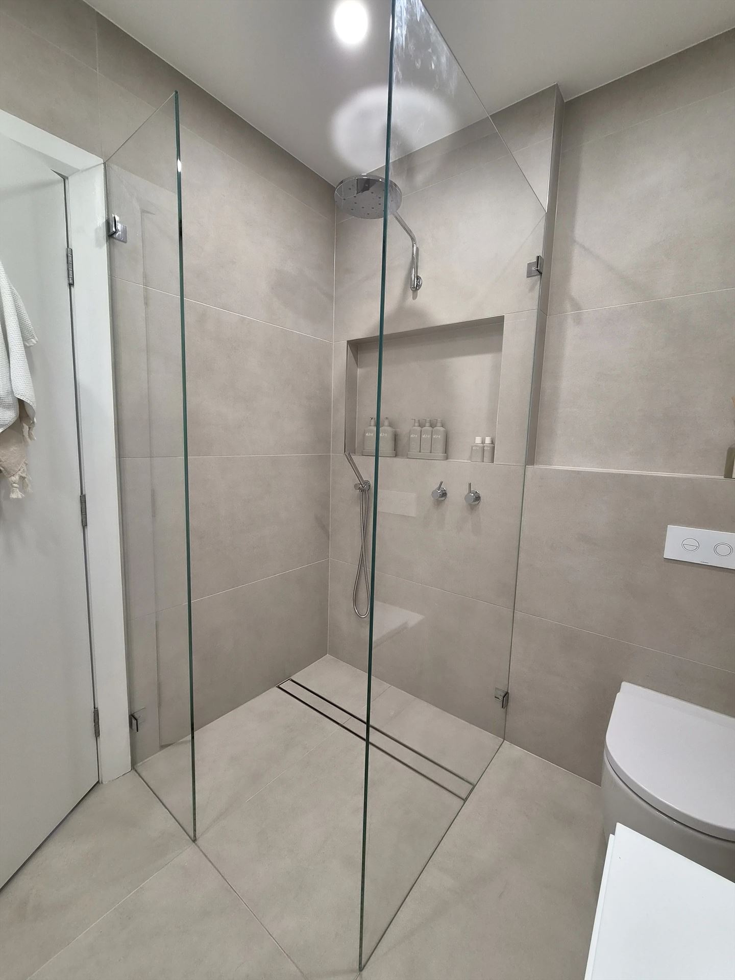 frameless shower screen with chrome hardware installed in Rodd Point by Showerland