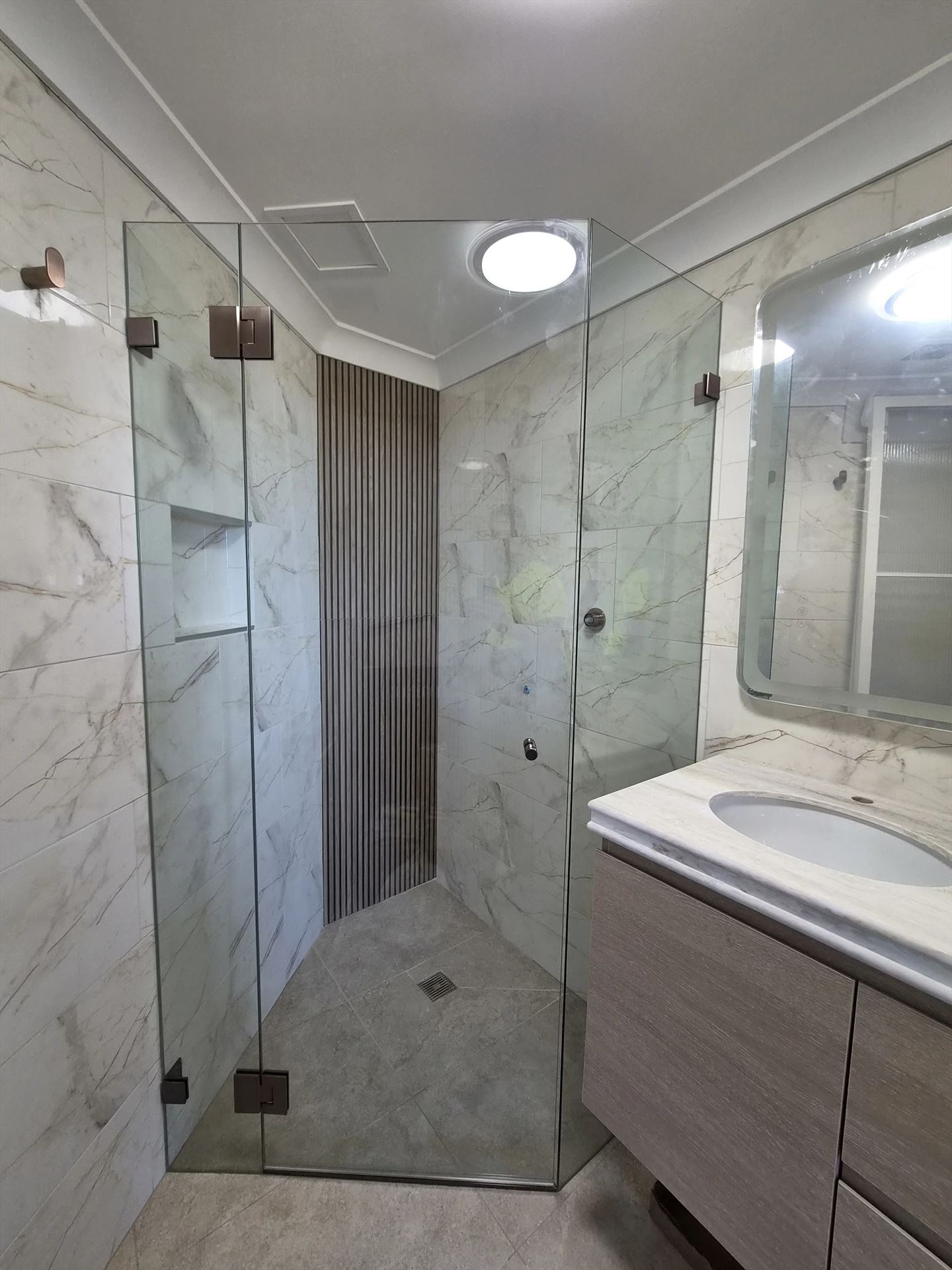 frameless shower screen with chrome hardware installed in Liberty Grove by Showerland