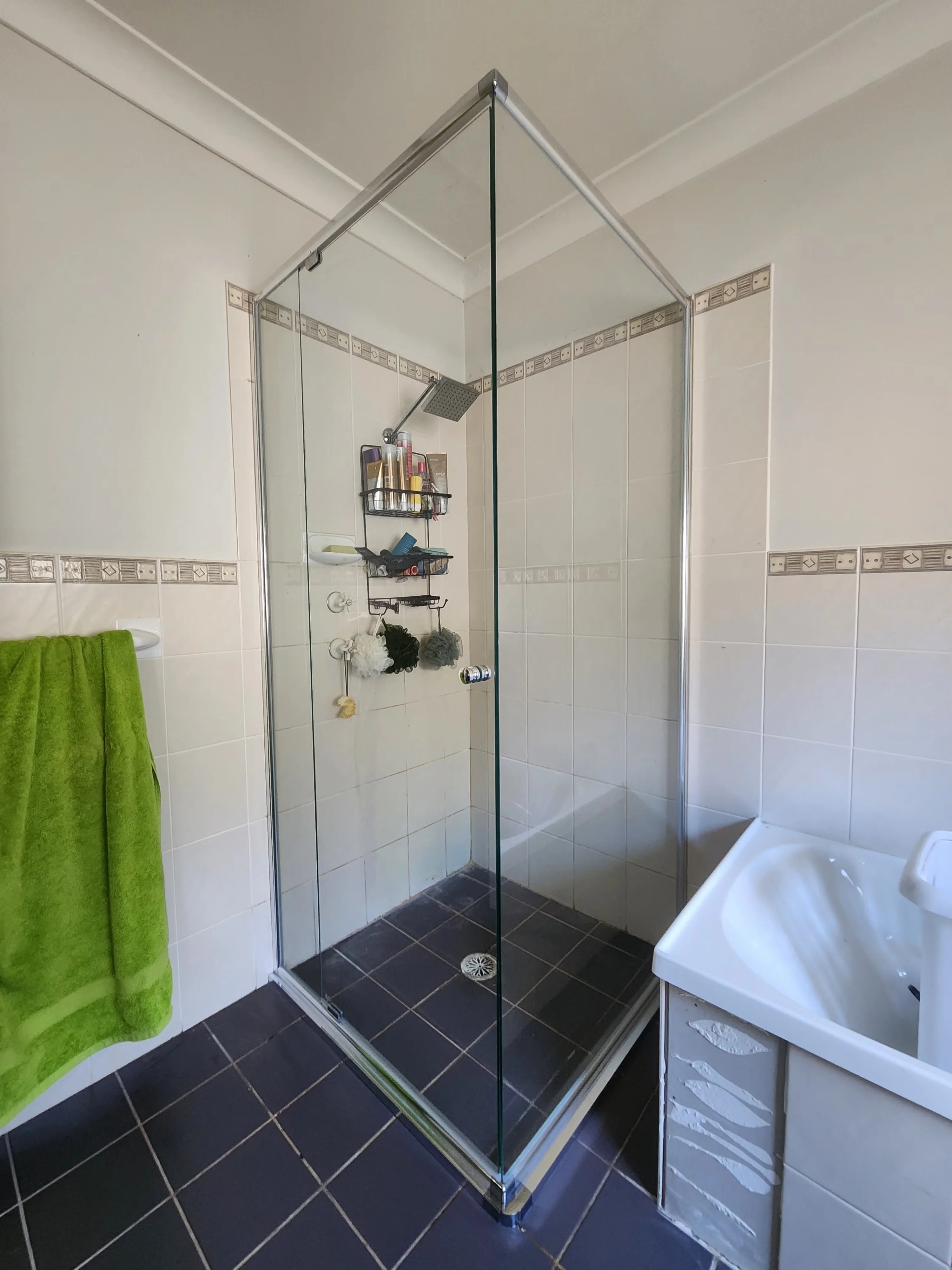 Custom semi-frameless corner shower screen with pivot door on a hub, Sydney