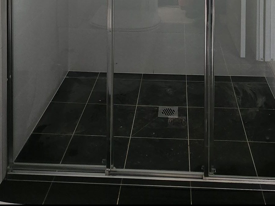 Rollers and track on a sliding shower door in Earlwood
